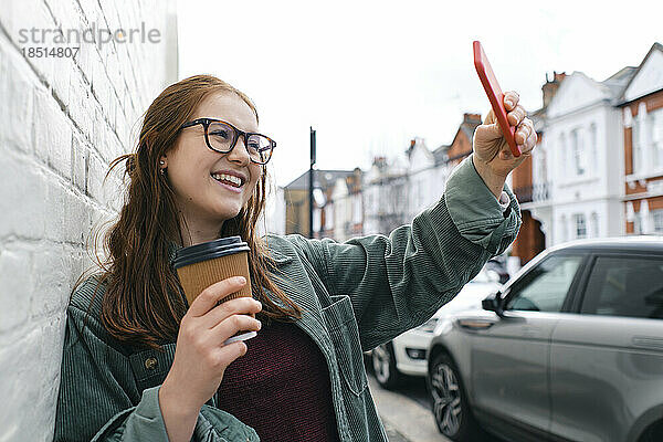 Glückliche junge Frau  die ein Selfie mit dem Smartphone macht