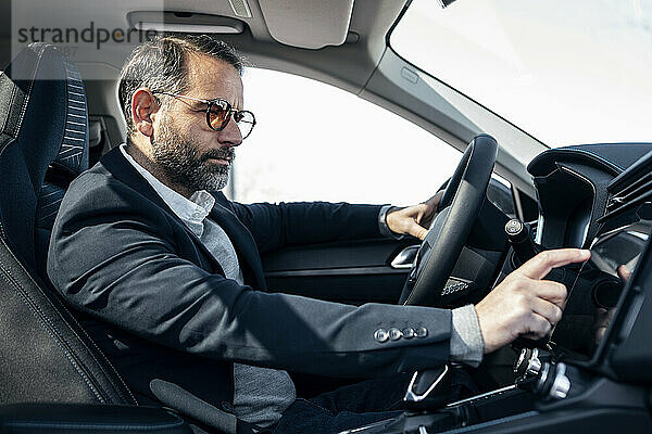 Geschäftsmann nutzt GPS-System im Elektroauto
