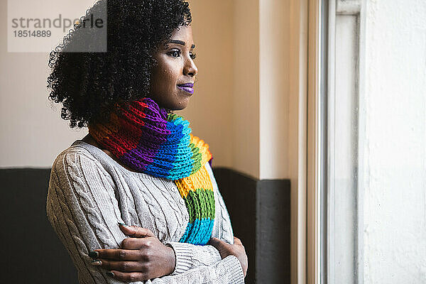 Woman wearing multi colored scarf looking out of window