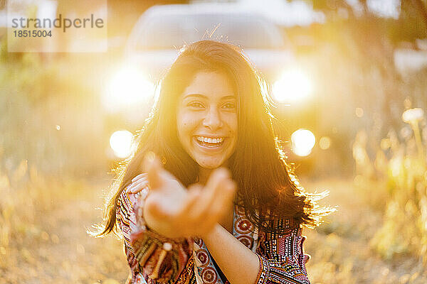 Happy young woman gesturing in field
