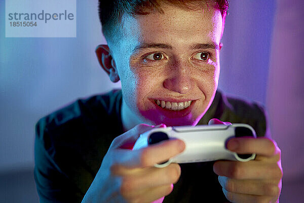 Glücklicher junger Mann  der Videospiel spielt