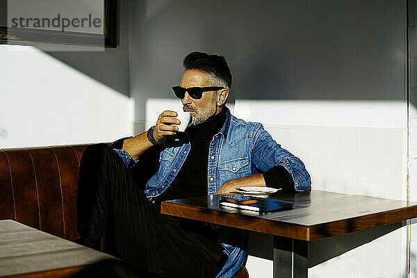 Geschäftsmann mit Sonnenbrille trinkt Kaffee