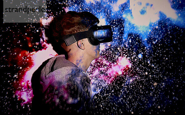 Junger Mann mit VR-Brille vor der Projektionsfläche