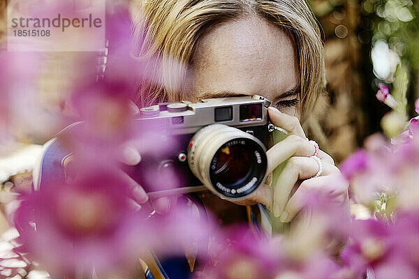 Frau fotografiert mit Kamera im Garten