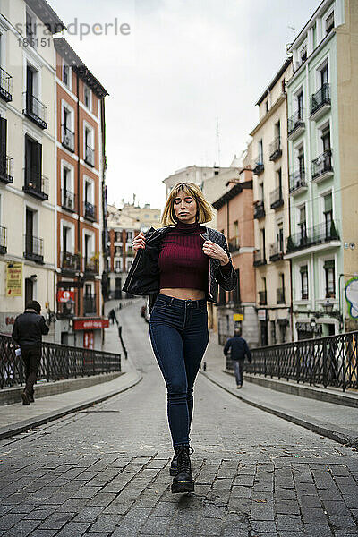 Frau läuft auf der Straße inmitten von Gebäuden in der Stadt