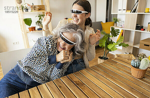 Glückliche Mutter und Tochter mit Smart-Brille  die zu Hause Spaß haben