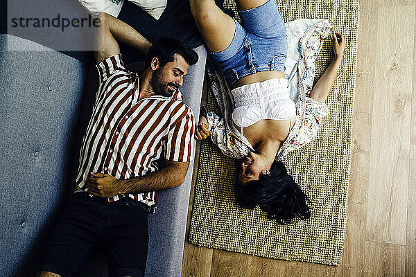 Man and woman lying down together at home