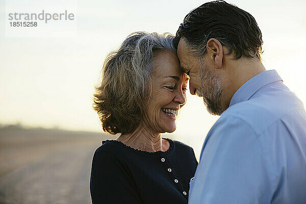 Glückliches älteres Paar  das sich am Strand genießt und umarmt