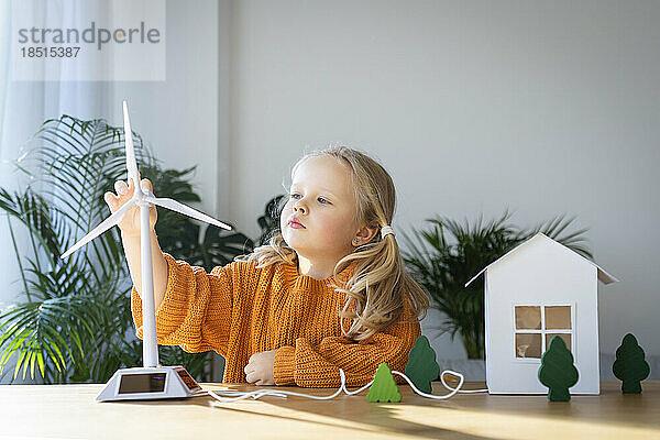 Mädchen hält Windturbinenmodell zu Hause