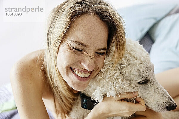 Glückliche Frau umarmt Hund zu Hause