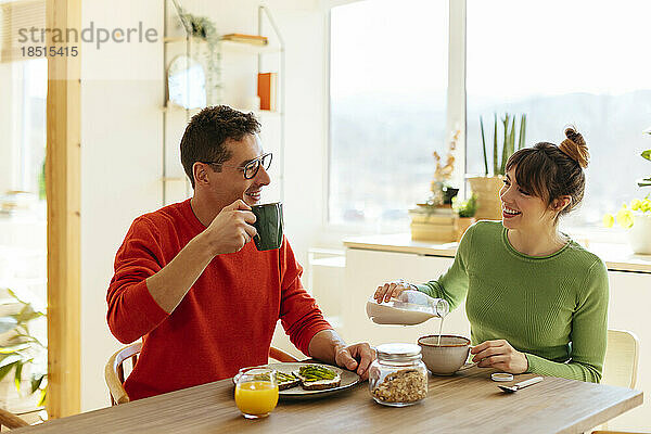 Glückliches Paar beim Frühstück zu Hause