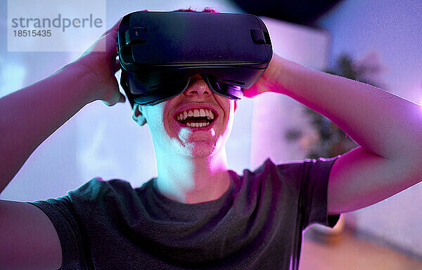 Glücklicher Mann  der zu Hause einen Virtual-Reality-Simulator trägt