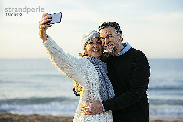 Glückliche reife Frau  die Selfie vor dem Meer macht