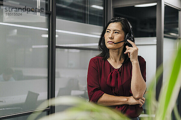 Nachdenkliche Geschäftsfrau mit Headset im Büro