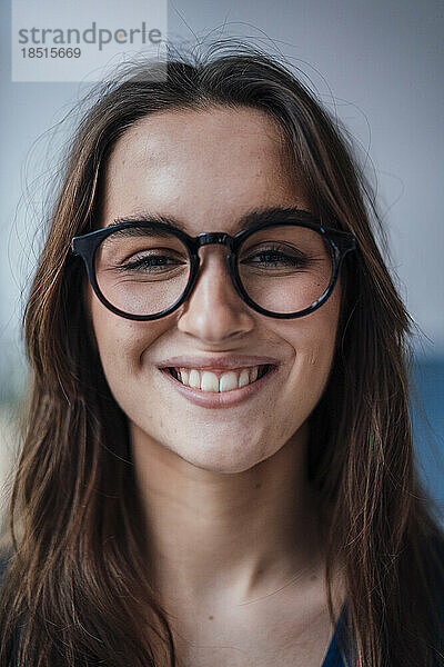 Glückliche junge Geschäftsfrau mit Brille
