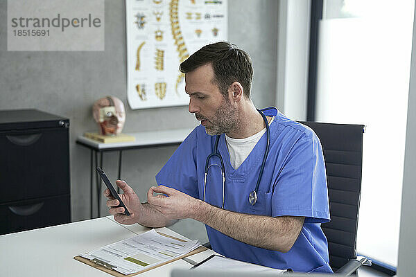Arzt spricht per Videoanruf über Smartphone in der Klinik