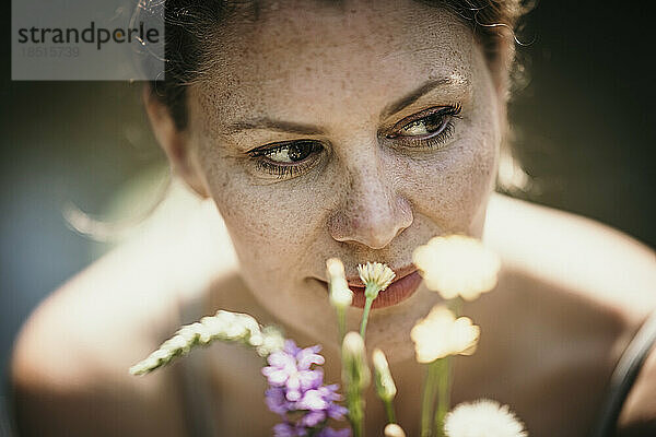 Thoughtful mature woman by flowers