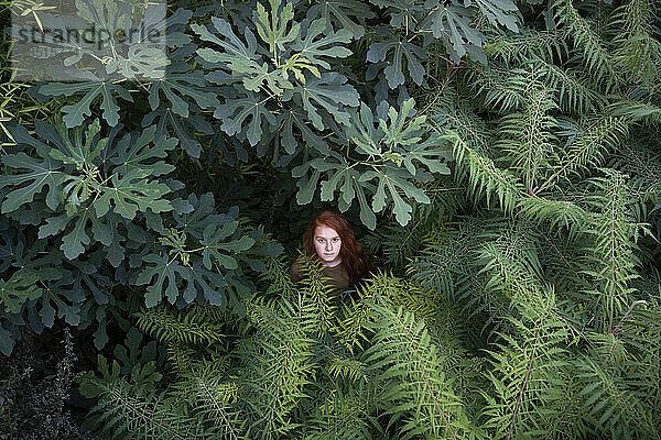 Mädchen steht inmitten von Pflanzen in der Natur