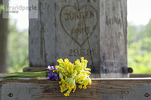 Bouquet of yellow flowers lying on wooden bench