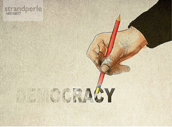 Hand hält Bleistift und löscht Demokratietext