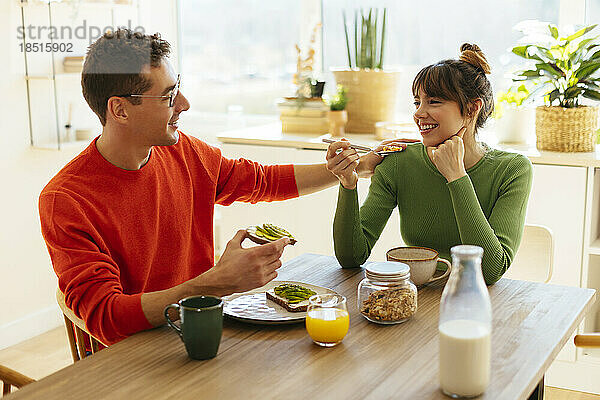 Glückliche Frau und Mann beim Frühstück zu Hause