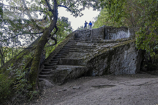 Men standing over Etruscan Pyramid of Bomarzo