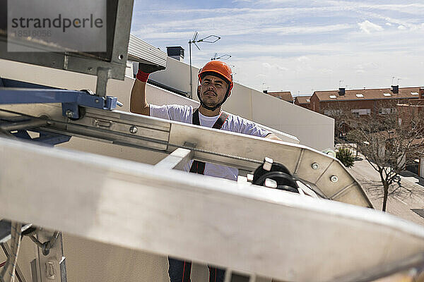 Junger Ingenieur arbeitet auf dem Dach