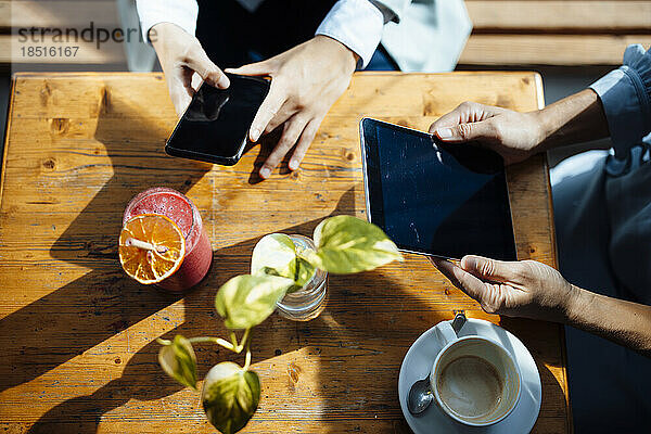 Frauen mit Tablet-PC und Smartphone im Café