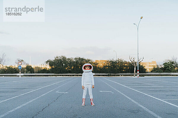 Als Astronaut verkleidetes Mädchen steht auf dem Parkplatz