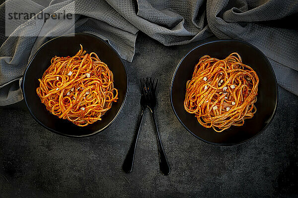 Studio shot of two bowls of vegan linguine with paprika almond sauce