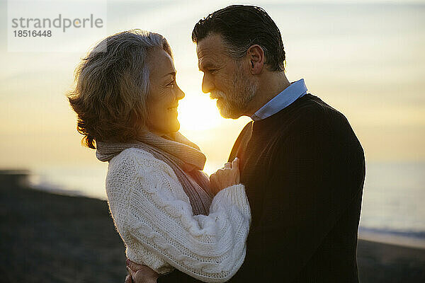 Reifer Mann und Frau umarmen sich bei Sonnenaufgang