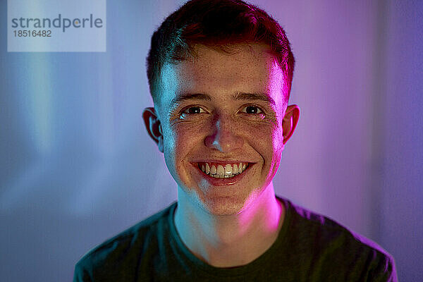 Cheerful young man with light on face
