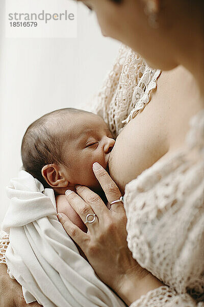 Mother breastfeeding newborn baby boy