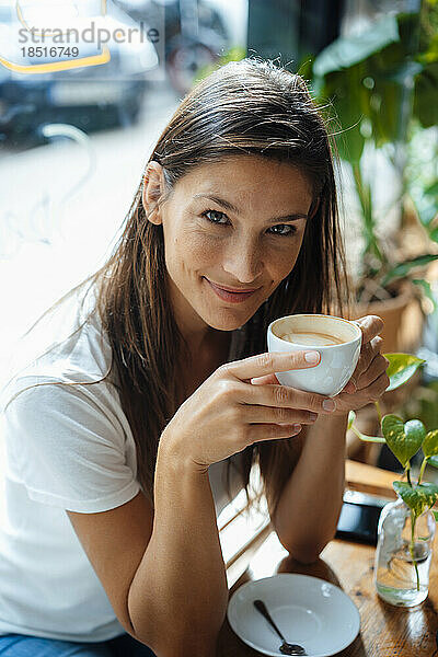 Lächelnde Frau  die Kaffee im Café trinkt