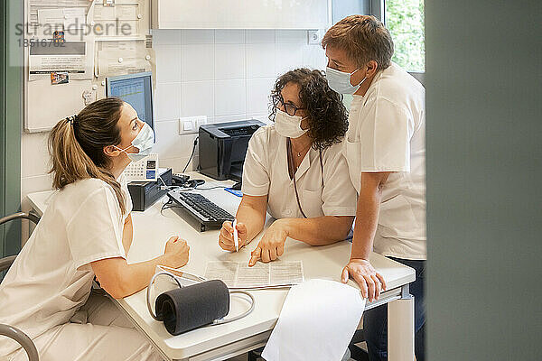 Krankenschwestern mit Schutzmasken diskutieren gemeinsam in der Klinik
