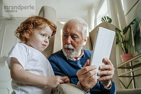 Großvater zeigt Enkel-Tablet-Computer zu Hause