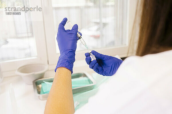 Hände eines Arztes  der im Krankenhaus eine Impfspritze vorbereitet