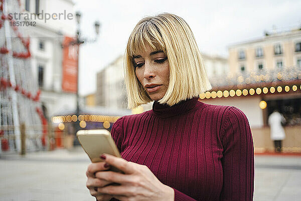 Frau surft mit Mobiltelefon im Internet