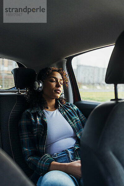 Junge Frau mit geschlossenen Augen entspannt sich im Auto