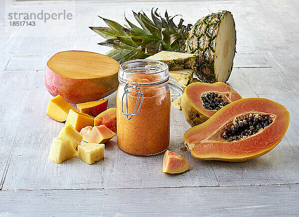 Halbierte Mangofrüchte  Papaya  Ananas und Smoothie im Glas