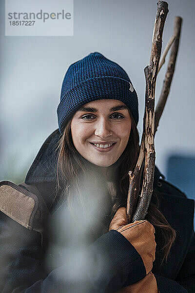 Glückliche junge Frau  die Brennholz hält