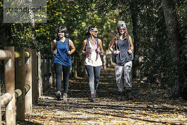 Happy mother walking with daughters on footpath