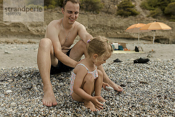 Vater und Tochter spielen am Strand