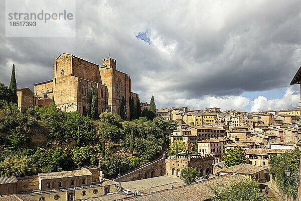 Italien  Toskana  Siena  dichte Wolken über der Basilika San Domenico und den umliegenden Häusern