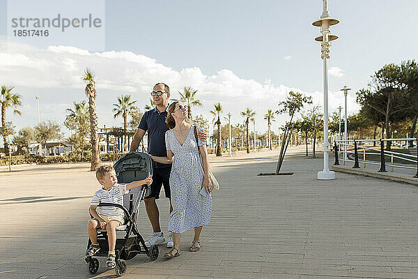 Glückliche Familie  die an einem sonnigen Tag am Ufer spaziert