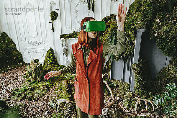 Rothaarige Frau gestikuliert mit Virtual-Reality-Simulator