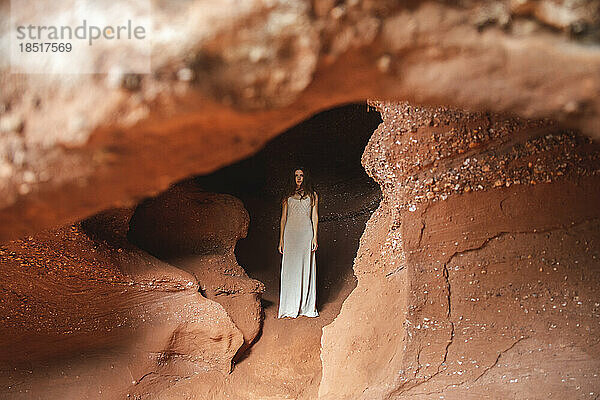 Frau steht in roter Höhle