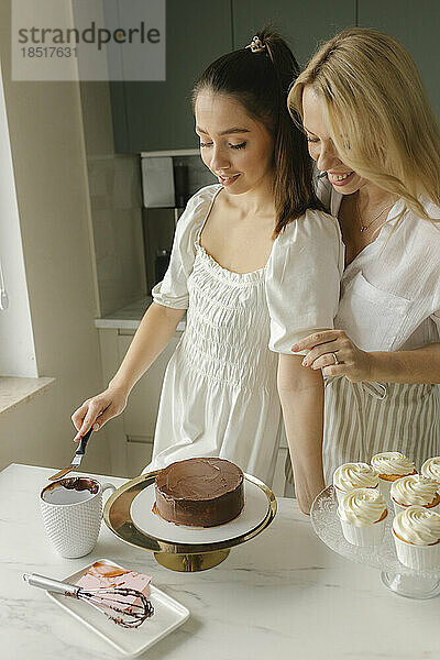 Glückliche Freunde  die zu Hause Kuchen zubereiten