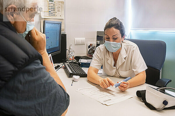 Arzt erklärt dem Patienten in der Klinik medizinische Geräte