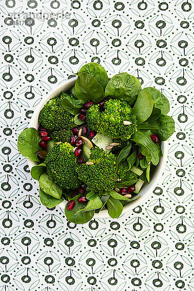 Bowl of green salad with broccoli  corn salad  cashews  cucumber and various seeds